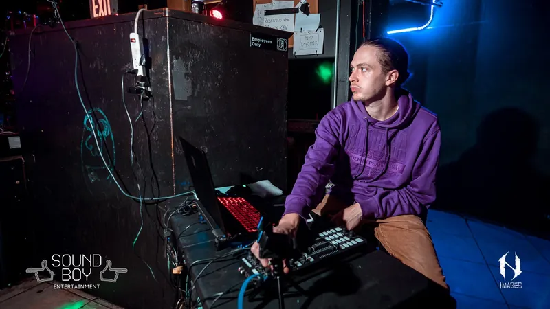 person looking left with their hand on a midi controller